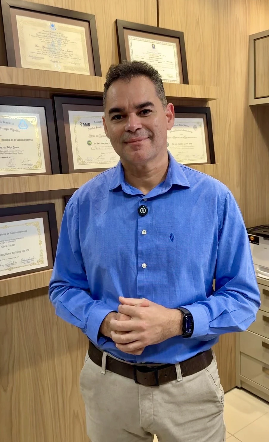 Dr. Luiz Gonçalves con sus diplomas en el consultorio